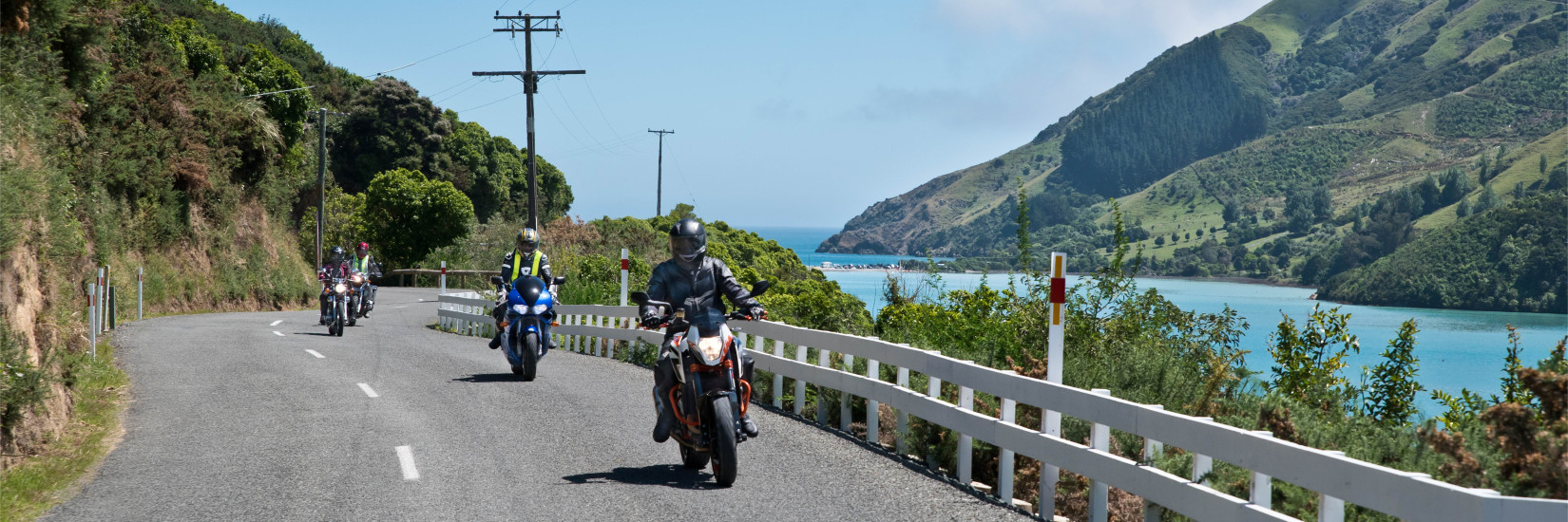 Group of bikes riding on a road beside a river