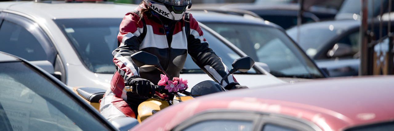 Motorcyclist riding through cars