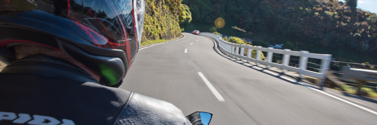 Over the shoulder view of motorcyclist on open road