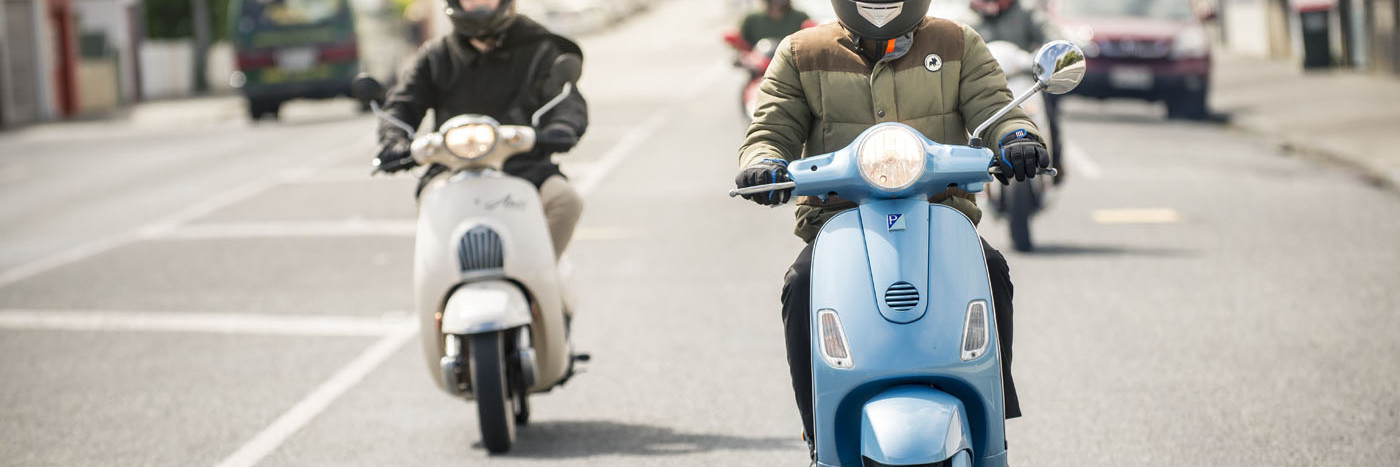 Group of scooter riders on road