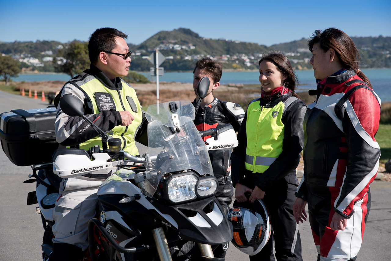 Group of riders in gear talking to instructor by bike