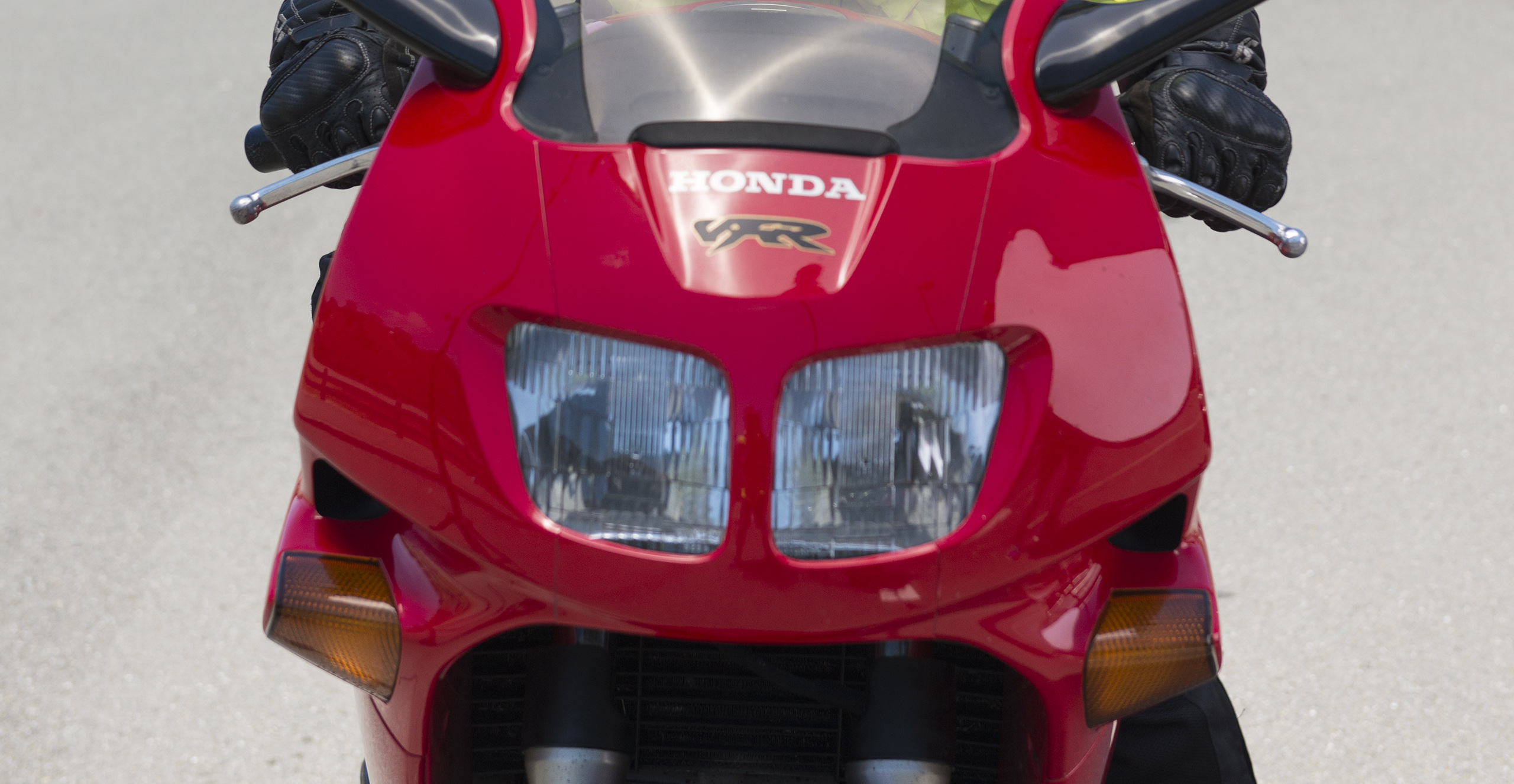 Close up of front of a red sport/performance bike with rider