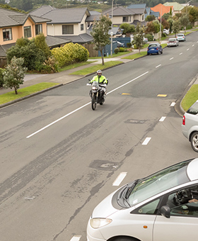 Bike riding straight with car on side street to the left